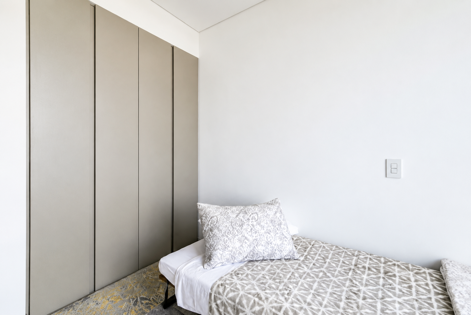Single bed and wardrobe in the Cayalá apartment second bedroom